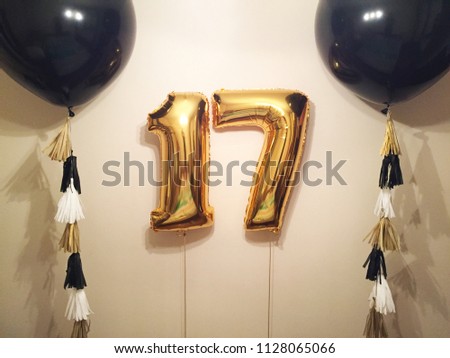 A composition of giant helium air balloons of black color with tassel garlands, large figures of seventeen gold. Gift of the boyfriend for seventeen years