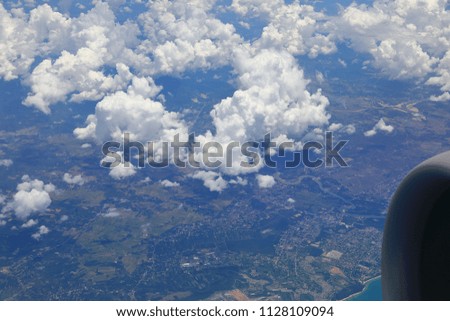 View from a plane, beautiful white clouds and raincloud in blue sky