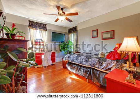 Bedroom with hardwood floor and grey walls with red desk.