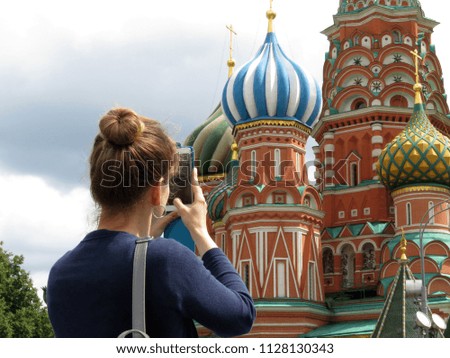 Woman tourist taking pictures with smartphone the St. Basil's cathedral on Red square in Moscow. Tourism in Russia