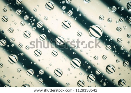 Water droplets on glass and cotton colorful backdrop.