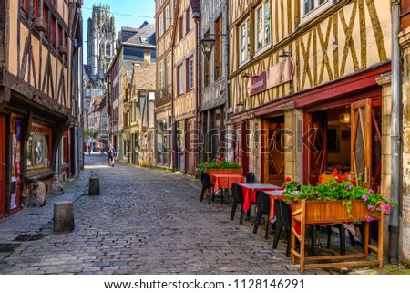 Cozy street with timber framing houses and tables of restaurant in Rouen, Normandy, France Royalty-Free Stock Photo #1128146291