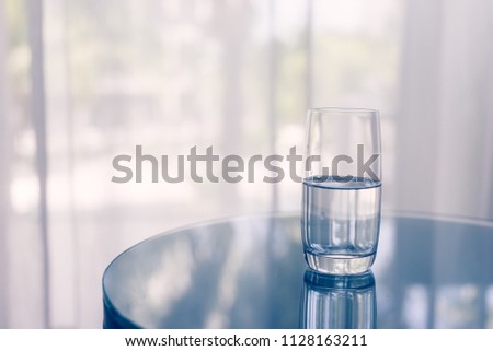 Glass of clean water on the table. Home. Royalty-Free Stock Photo #1128163211