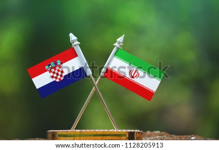 Iran and Croatia small flag with blur green background
