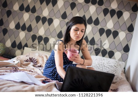 Woman using laptop and mobile phone at home