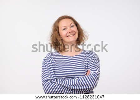 Smiling european lady in marine pulover looking at camera, isolated on gray background. Be self confident and independent. Kind ezpression on face