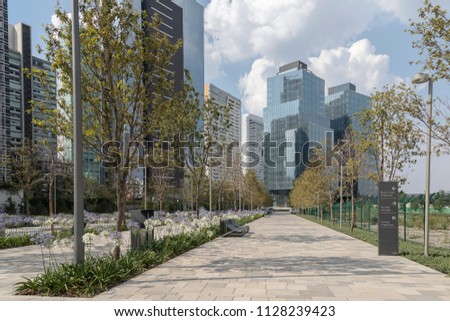 La Mexicana park in Santa Fe, Mexico City with modern buildings beside and young trees