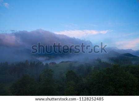 Photo of misty morning fog at the sunrise in the mountains. Ukraine, Carpathians, Dzembronia village