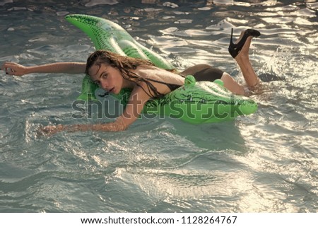 Summer rest. Portrait of a beautiful woman lying on air mattress in swimming pool.