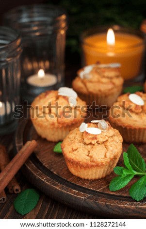 Gluten free pumpkin and carrot muffins decorated with almonds on dark wooden cutting board. Thanksgiving Day dessert