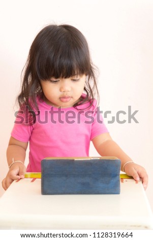 Cute asian little girl watching cartoon on smart phone.