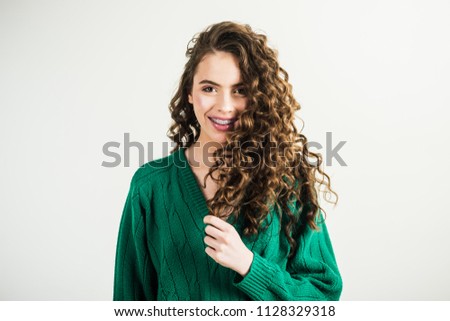 Fashion woman in green sweater. Fashion look and beauty concept. girl with curly hair at hairdresser at white wall. Retro girl with stylish makeup and hair in paris. Parisian girl in winter clothes.