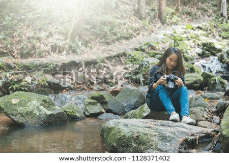 Photography and travel The girl holding the camera in humid forest zone.