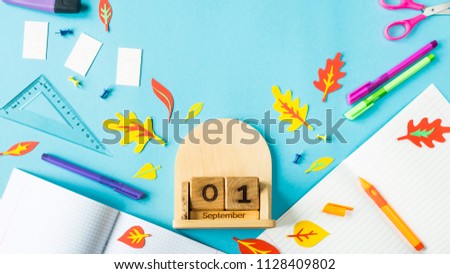 September 1 on a wooden calendar among the supplies for study on a blue background. Back to school concept Royalty-Free Stock Photo #1128409802