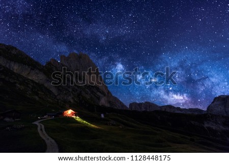 The night sky peppered with thousands of stars over Seceda Dolomites, Italy