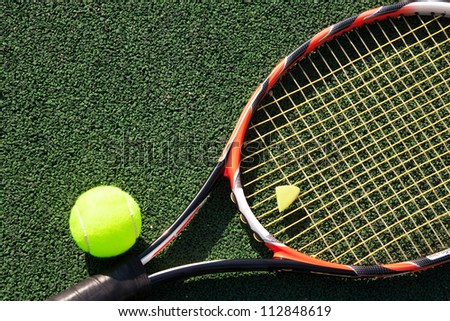 A tennis racket and new tennis ball on green court Royalty-Free Stock Photo #112848619