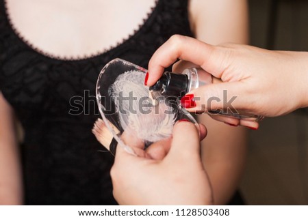 makeup woman squeezing the mixed foundation on a glassy surface before applying it on a face of a model. concept of natural make up Royalty-Free Stock Photo #1128503408