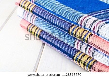 Stack of towels in cage on white wooden table. Studio Photo