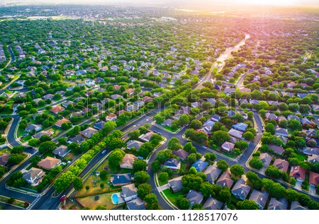 Sun glows Sunset real estate suburb homes. Community suburbia neighborhood in north Austin in suburb Round Rock , Texas Aerial drone view above new development Royalty-Free Stock Photo #1128517076