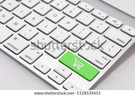 White wireless  style keyboard with green "shopping cart" symbol key