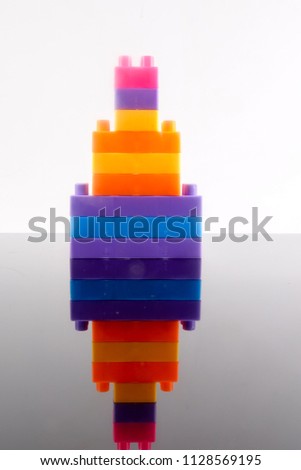 Plastic building blocks isolated on white background with reflection.