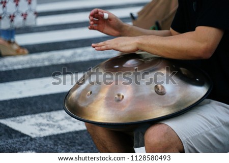 musician play handpan song in the street blur background