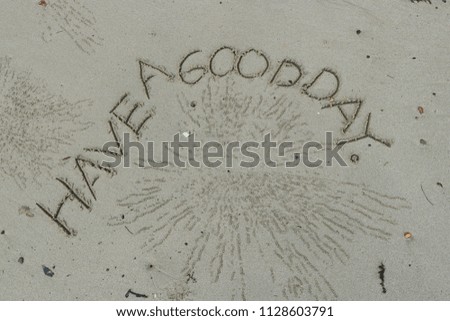 Handwriting  words "HAVE A GOOD DAY." on sand of beach.
