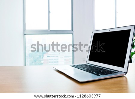 Sinlge laptop on table in office.