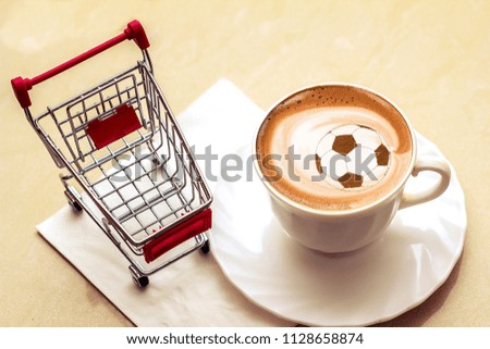 coffee cappuccino in a cup with a picture of a soccer ball made from cinnamon on milk foam