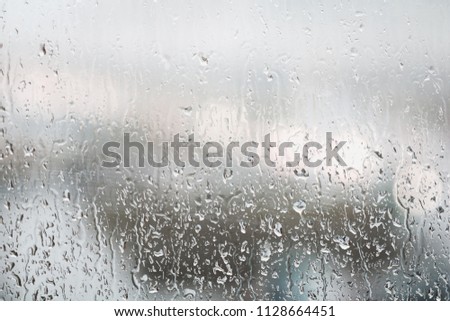 Raindrops on a window in evening. Refocused background.
