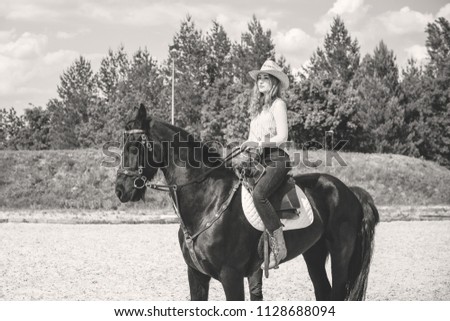 Nice american lady in a plaid shirt and hat. A beautiful rider gently hugs the horse. Artistic Photography at horse farm