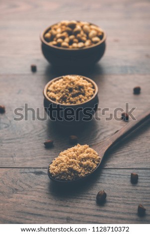 Crushed peanuts or mungfali powder with whole and roasted groundnut. Served in a bowl over moody background. Selective focus