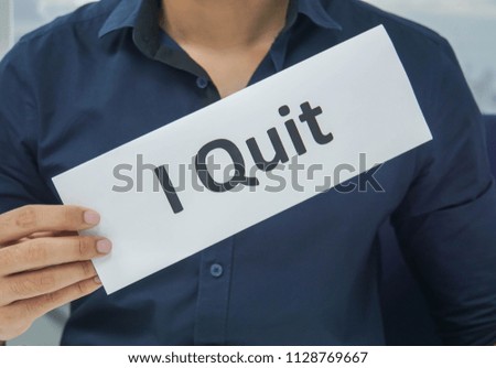 close up businessman hold paper sheet of I quit as resignation letter from the office