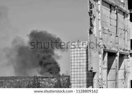 Template in the form of a building wall against the sky and thick black smoke. The problem of environmental pollution. Black and white.
