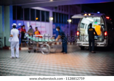 Medical team helping to moving patient from ambulance for treatment in hospital blurred.