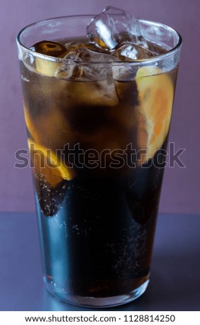 Glass  with cola lemon and ice like whiskey cola or long island cocktail