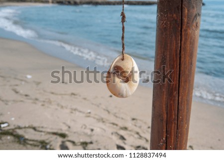 Hanging seashell decoration on the sea and the beach background