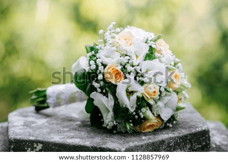 Tender spring wedding white and green bouquet from the stone background. Bouquet of bride.