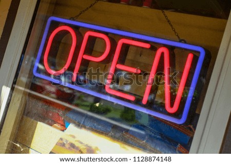 An open for business neon sign at a beach restaurant