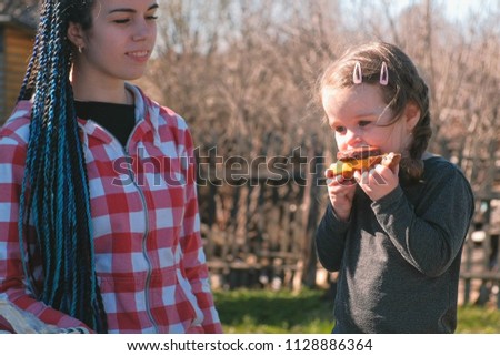 Mom feed sandwich her little daughter.