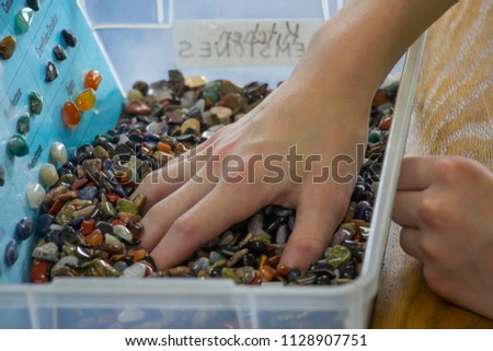 Young boy hand searching for the perfect semi-precious stone