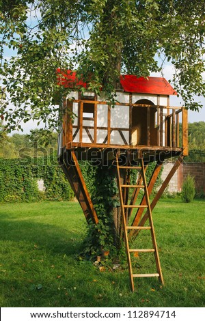 Cute small tree house for kids on backyard. German style.