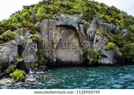 Travel New Zealand, North Island, Taupo. Cruise view of Iconic Maori rock carving in the rock on Great Lake Taupo. Popular tourist attraction/activity. Royalty-Free Stock Photo #1128960749
