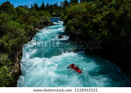 Travel New Zealand. Most popular tourist attraction Huka Falls at Lake Taupo, North Island. White and turquoise water, green forest on background. Beautiful landscape view. Active summer holidays. 