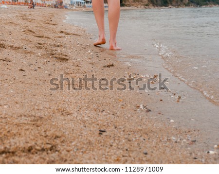Walking barefoot on the beach in Greece
