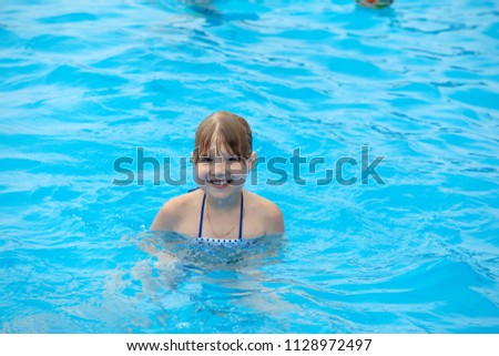 Happy little girl swimming in the pool
