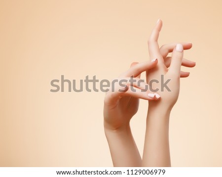 Beautiful Woman Hands. Female Hands Applying Cream, Lotion. Spa and Manicure concept. Female hands with french manicure. Soft skin, skincare concept. Hand Skin Care. Royalty-Free Stock Photo #1129006979