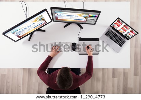 High Angle View Of Designer Making Web Page Design On Computer Using Graphic Tablet