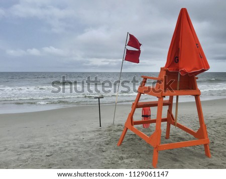 Closed beach warning flags on lifeguard stand