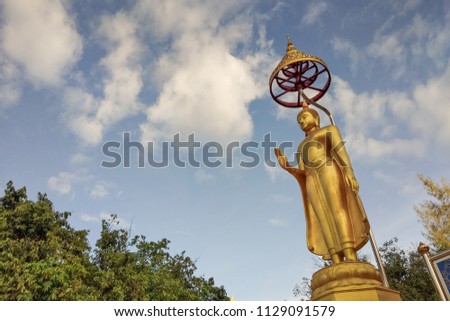 ant's eye view of standing buddha with many clouds moving with blue sky background, Wat Dontoom, Banpong, Ratchaburi, Thailand